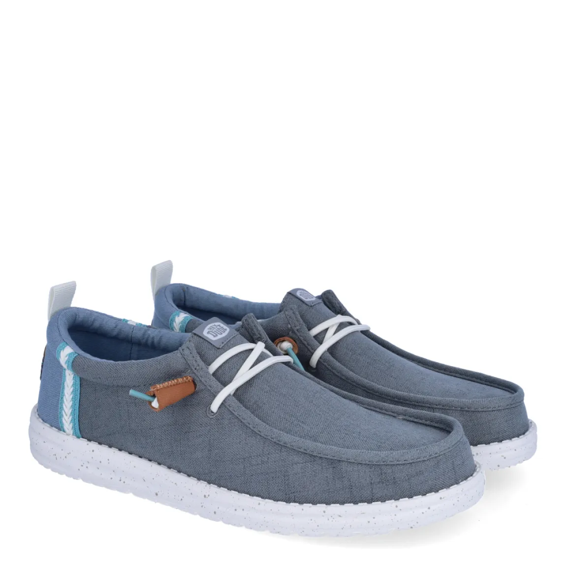 Náuticos de la marca Hey Dude, modelo WALLY. Exterior de los náuticos en ante color gris. Interior de los náuticos en tela color gris y plantilla acolchada y extraíble. Cierre de los náuticos Hey Dude con cordones elásticos blancos y suela plana de goma. Estos náuticos Hey Dude WALLY, son el complemento perfecto para esta temporada, los podrás lucir con la máxima comodidad posible.
