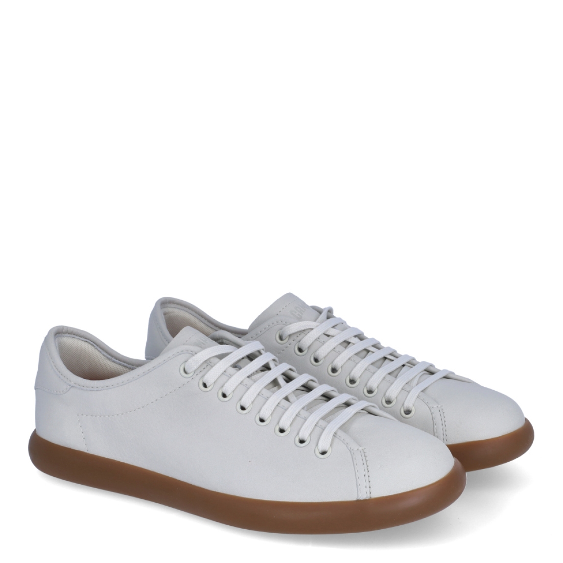 Deportivas de la marca Camper, modelo K100. Exterior en piel color blanco. Cierre con cordones. Suela de goma plana color camel. Estas deportivas Camper K100 son un complemento ideal para disfrutar de la comodidad al caminar.