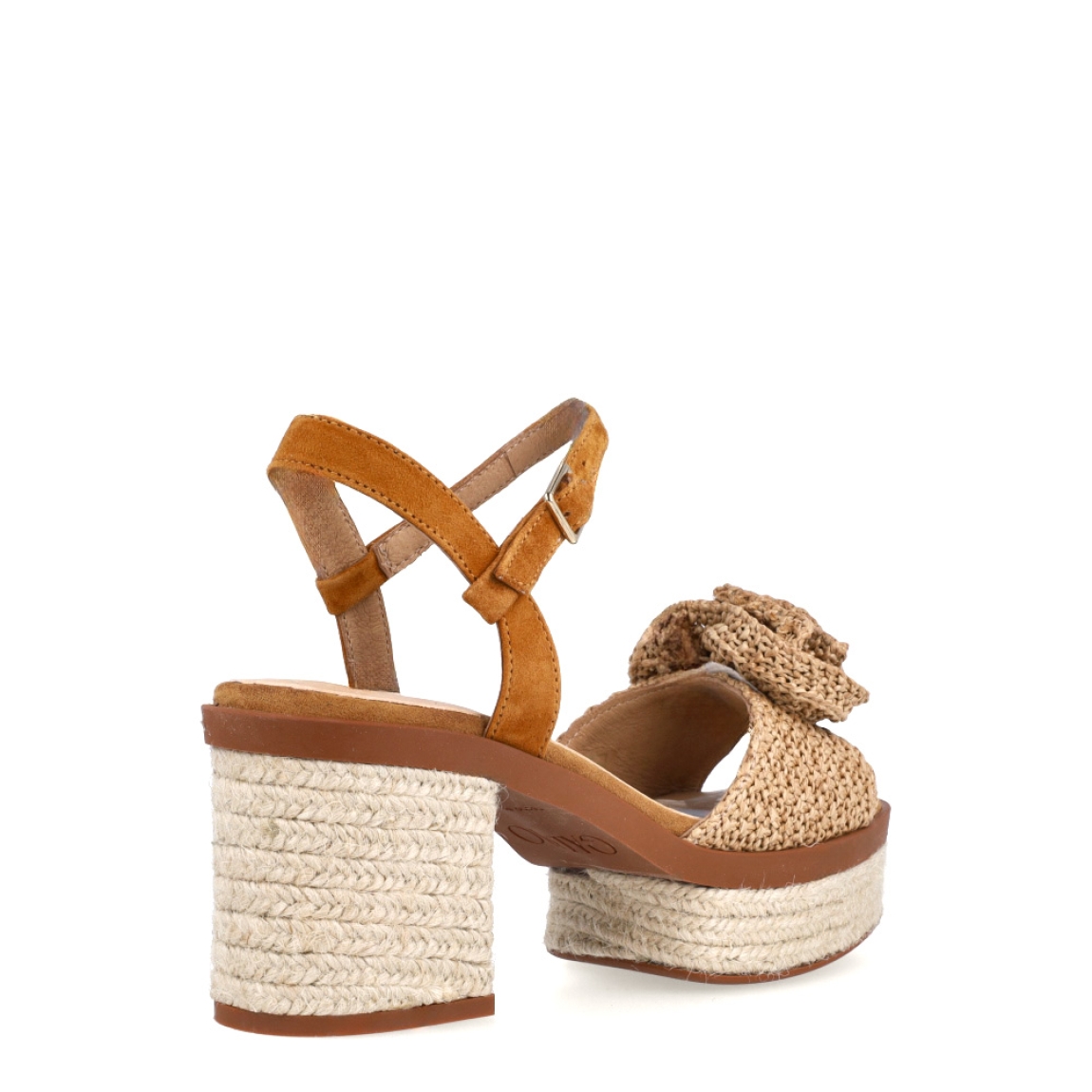 Sandalias de la marca Gaimo, modelo Luana. Elaboradas en rafia colo camel, combinan elegancia y comodidad con su propuesta en rafia natural, con un delicado adorno de flor y talón abierto con pulsera ajustable. Cierre con hebilla en tobillo y un tacón de 8cm de altura. Elaboradas artesanalmente en Arnedo, España, con materiales de alta calidad y 100% naturales, las sandalias Luana son la opción perfecta para quienes buscan elevar sus looks veraniegos.