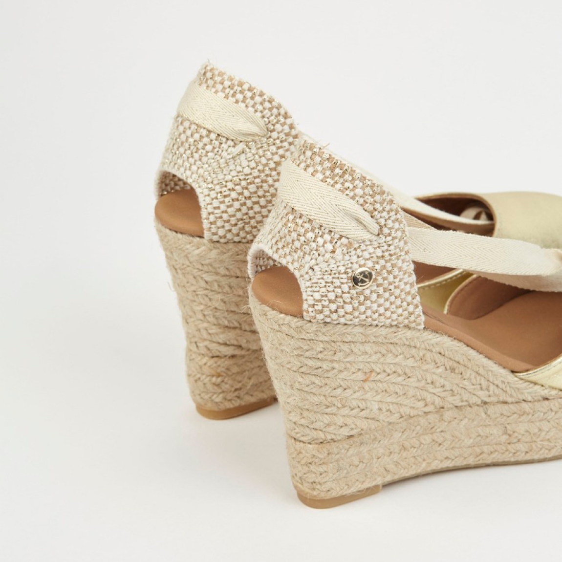 Alpargatas de la marca La Valeta, modelo CHARLENE. Exterior en piel color oro con punta redonda, forrada en microfibra transpirable. Plantilla de microfibra transpirable acolchada. Alpargatas con tiras de tela para un cierre con nudo. Plataforma en yute artesanal con cuña de 10cm de altura. Estas alpargatas La Valeta CHARLENE son ideales para esta temporada!