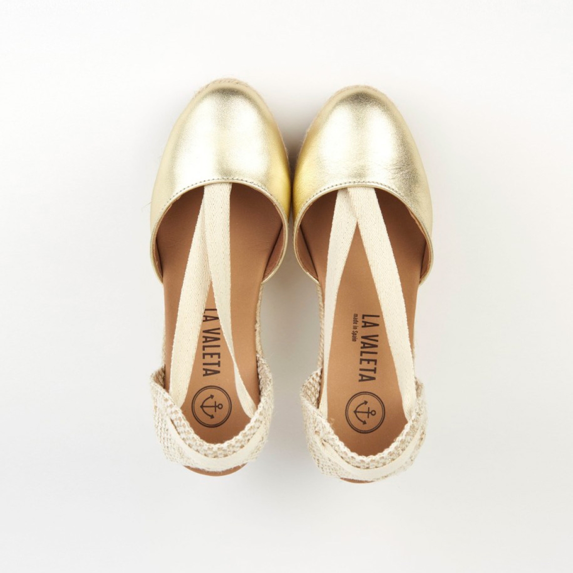 Alpargatas de la marca La Valeta, modelo CHARLENE. Exterior en piel color oro con punta redonda, forrada en microfibra transpirable. Plantilla de microfibra transpirable acolchada. Alpargatas con tiras de tela para un cierre con nudo. Plataforma en yute artesanal con cuña de 10cm de altura. Estas alpargatas La Valeta CHARLENE son ideales para esta temporada!