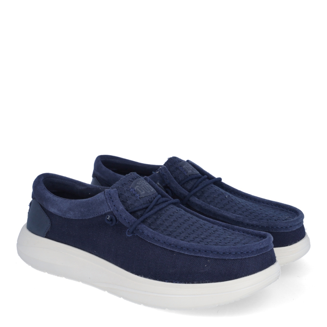Náuticos de la marca Hey Dude, modelo WALLY COMF WOVE. Exterior de los náuticos en tela color azul marino. Interior de los náuticos en tela color azul marino con plantilla acolchada y extraíble. Cierre de los náuticos Hey Dude con cordones elásticos y suela plana de goma. Estos náuticos Hey Dude WALLY COMF WOVE, son el complemento perfecto para esta temporada, los podrás lucir con la máxima comodidad posible.
