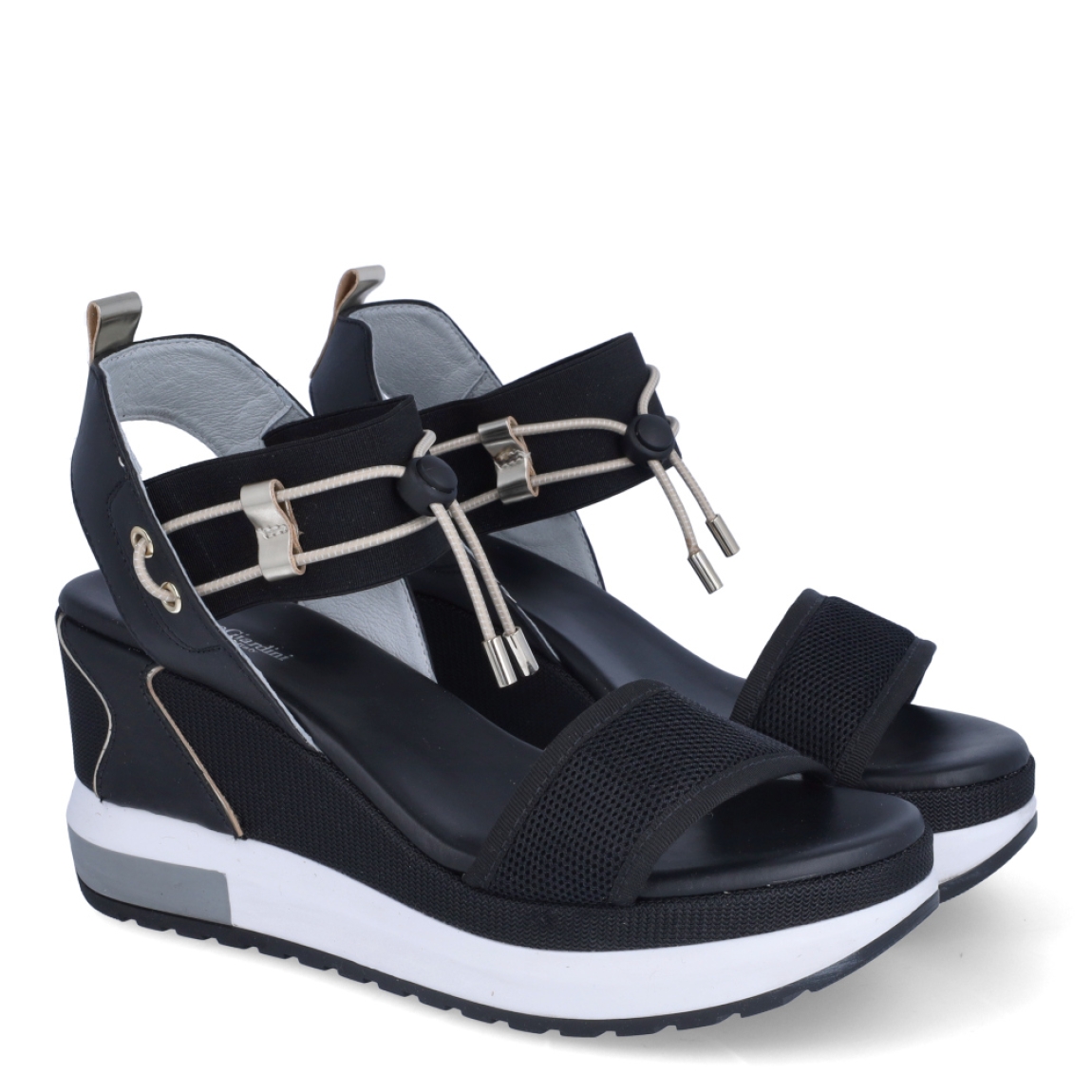 Sandalias de la marca Nerogiardini, modelo DANIE. Exterior de las sandalias en neopreno color negro con detalle de rejilla en la pala. Interior de las sandalias en piel color negro. Cierre de las sandalias Nerogiardini con gomas elásticas color dorado. Sandalias con cuña de 7cm de altura. Estas sandalias Nerogiardini DANIE es un complemento clásico, inspirado en la comodidad, ligereza que necesitas en tu día a día.