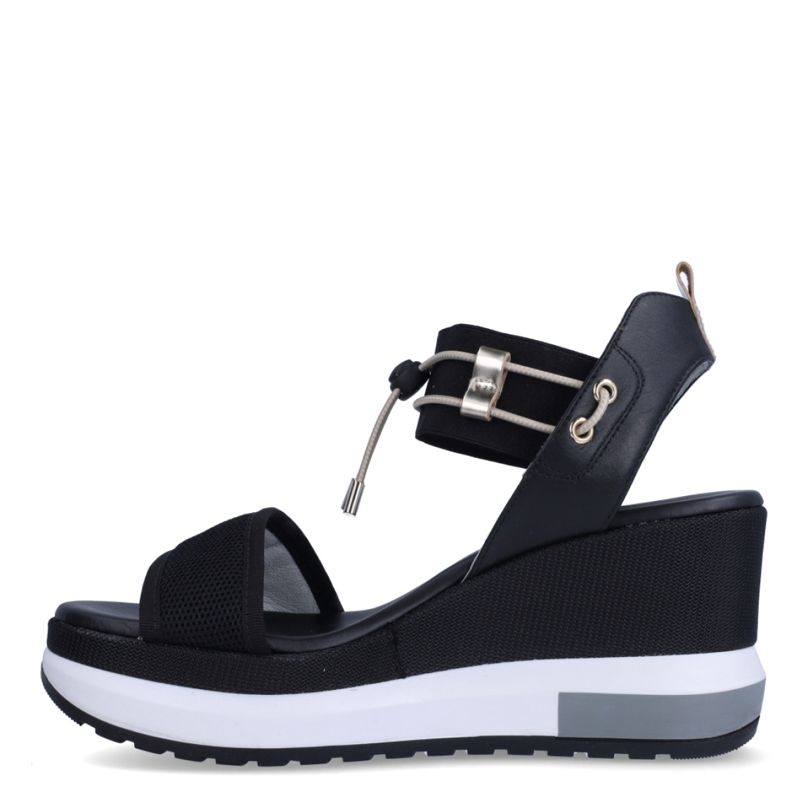 Sandalias de la marca Nerogiardini, modelo DANIE. Exterior de las sandalias en neopreno color negro con detalle de rejilla en la pala. Interior de las sandalias en piel color negro. Cierre de las sandalias Nerogiardini con gomas elásticas color dorado. Sandalias con cuña de 7cm de altura. Estas sandalias Nerogiardini DANIE es un complemento clásico, inspirado en la comodidad, ligereza que necesitas en tu día a día.