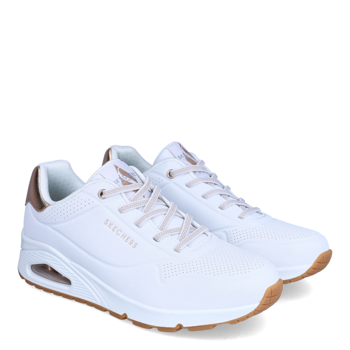 Deportivas de la marca Skechers, modelo UNO FLEX. Exterior en piel con detalle troquelado color blanco con detalle del logo en parte lateral y color bronce en talón. Interior en textil color blanco con plantilla acolchada y extraíble para máxima comodidad. Cordones de color blanco y una cuña de 3cm de altura. Estas deportivas Skechers UNO FLEX son unas clásicas, ideales para tu día a día.