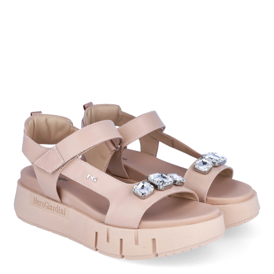 Sandalias de la marca Nerogiardini, modelo QUILME. Exterior de las sandalias en piel color nude con detalle de piedreria en la pala. Interior de las sandalias en piel color nude. Cierre de las sandalias Nerogiardini con velcro. Sandalias con cuña de 5cm de altura. Estas sandalias Nerogiardini QUILME son un complemento clásico, inspirado en la comodidad, ligereza que necesitas en tu día a día.
