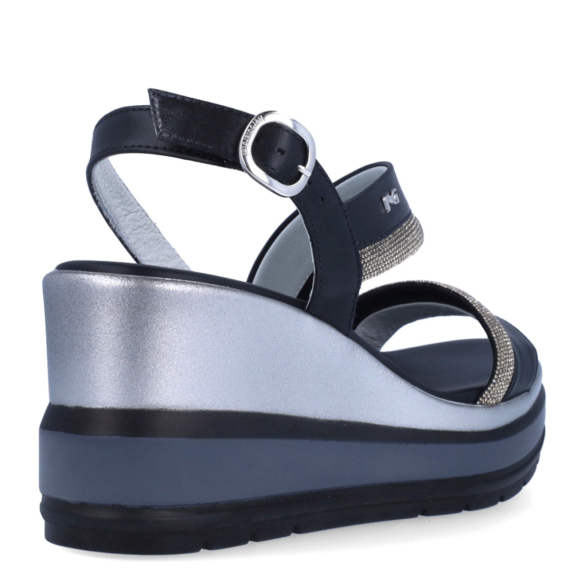 Sandalias de la marca Nerogiardini, modelo SOFF. Exterior de las sandalias en piel color negro con detalle de tiras brillantes color plateado en la pala. Interior de las sandalias en piel color negro. Cierre de las sandalias Nerogiardini con hebilla en tobillo. Sandalias con cuña de 8cm de altura. Estas sandalias Nerogiardini SOFF son un complemento clásico, inspirado en la comodidad, ligereza que necesitas en tu día a día.