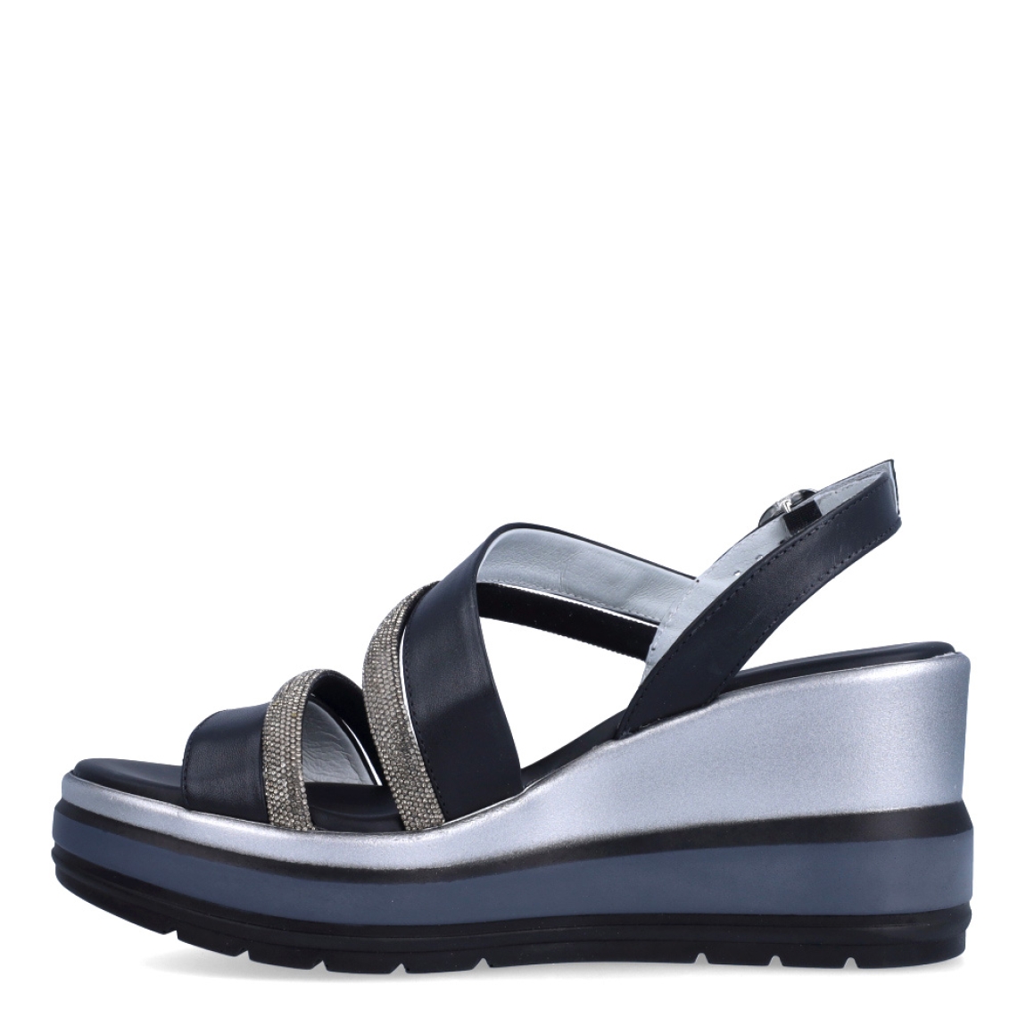Sandalias de la marca Nerogiardini, modelo SOFF. Exterior de las sandalias en piel color negro con detalle de tiras brillantes color plateado en la pala. Interior de las sandalias en piel color negro. Cierre de las sandalias Nerogiardini con hebilla en tobillo. Sandalias con cuña de 8cm de altura. Estas sandalias Nerogiardini SOFF son un complemento clásico, inspirado en la comodidad, ligereza que necesitas en tu día a día.
