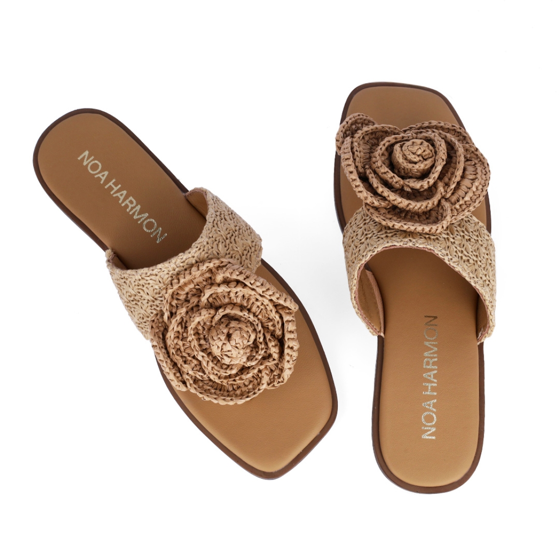 Esclavas de la marca Noa Harmon, modelo ACACIA. Elaboradas de rafia trenzada color cuero con detalle de flor en la pala. Interior en piel color cuero. Esclavas con suela plana. Estas esclavas Noa Harmon ACACIA son un complemento ideal para tus looks de esta nueva temporada!