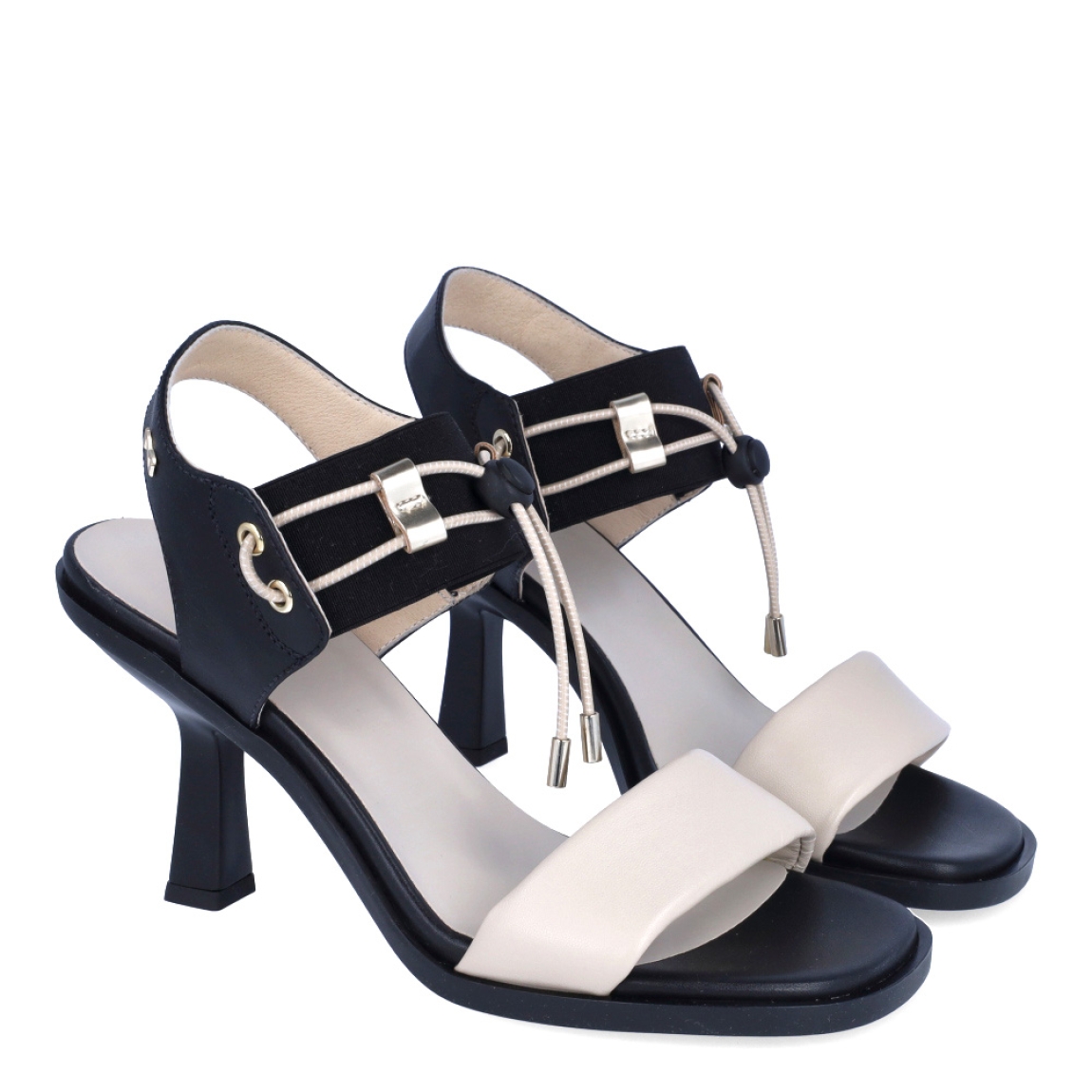 Sandalias de la marca Nerogiardini, modelo DANIA. Exterior de las sandalias en piel color beig. Interior de las sandalias en piel color negro y beig. Cierre de las sandalias Nerogiardini con gomas elásticas color negro. Sandalias con tacon de 6cm de altura. Estas sandalias Nerogiardini DANIA es un complemento clásico, inspirado en la comodidad, ligereza que necesitas en tu día a día.