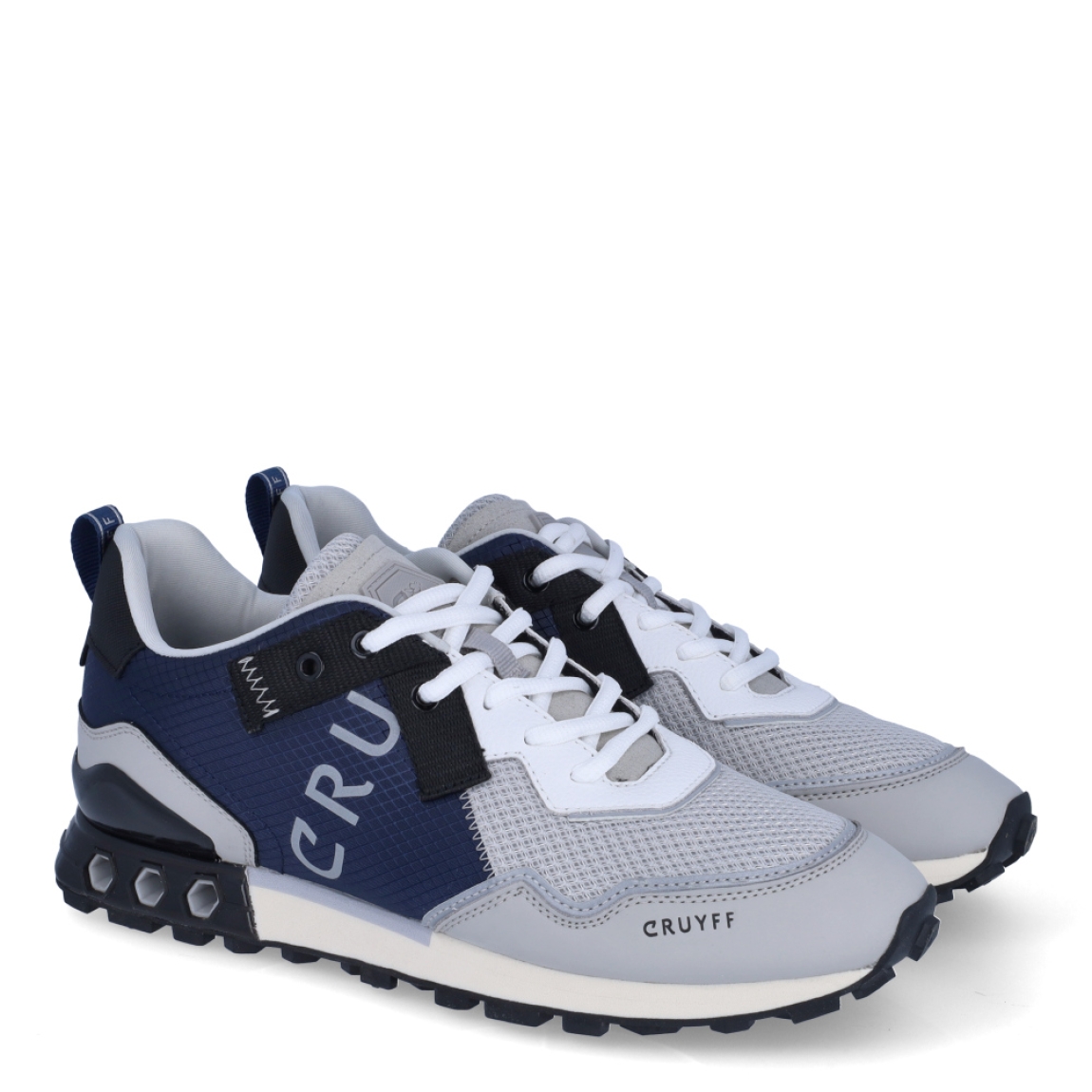 Deportiva de la marca Cruyff, modelo Superbia Hex-Tech. Exterior de la deportiva en nylon de color azul marino con efecto rejilla. Interior de la deportiva en textil de color gris. Cierre de la deportiva con cordones. Suela de goma dentada de 2 cm. Los tubos hexagonales son diseñados para permitir la entrada de aire a la parte posterior de la zapatilla, proporcionando un extra de soporte al pie. Plantilla muy cómoda, acolchada para garantizar el máximo confort. La deportiva Cruyff Superbia Hex-Tech es una nueva y exclusiva technología de Cruyff que mejora el rendimiento gracias a una mayor amortiguación.