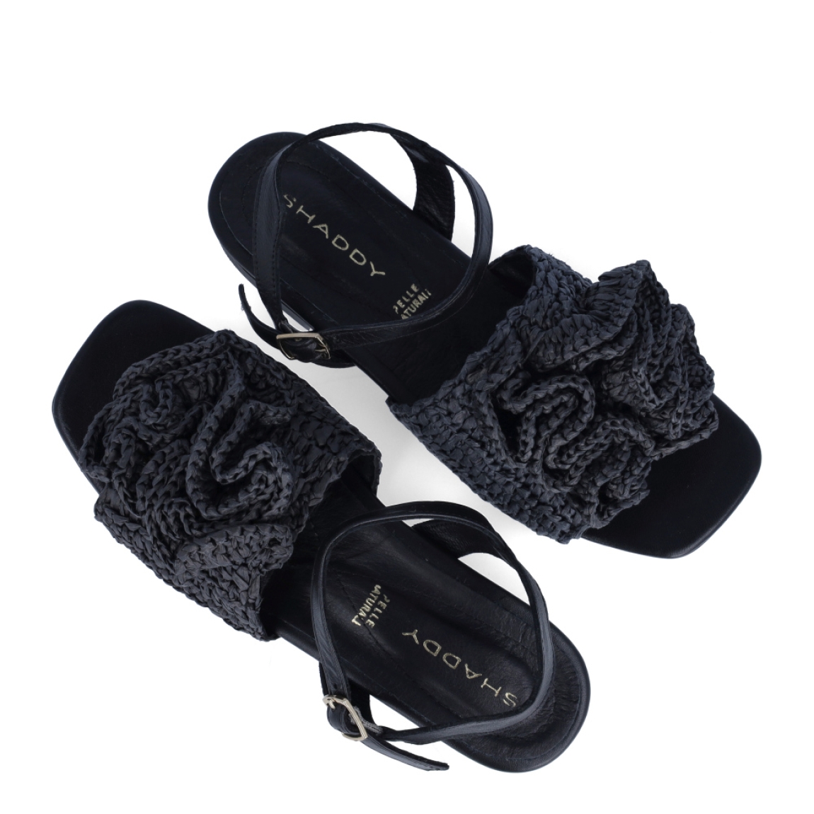 Sandalias de la marca Itse, modelo SHADY. Sandalias elaboradas en rafia trenzada color negro con detalles de flor en la pala. Cierre de las sandalias con hebilla en tobillo y suela de goma plana. Estas sandalias Itse SHADY son un complemento ideal para crear looks con personalidad y comodidad esta temporada. No te pueden faltar en el armario!