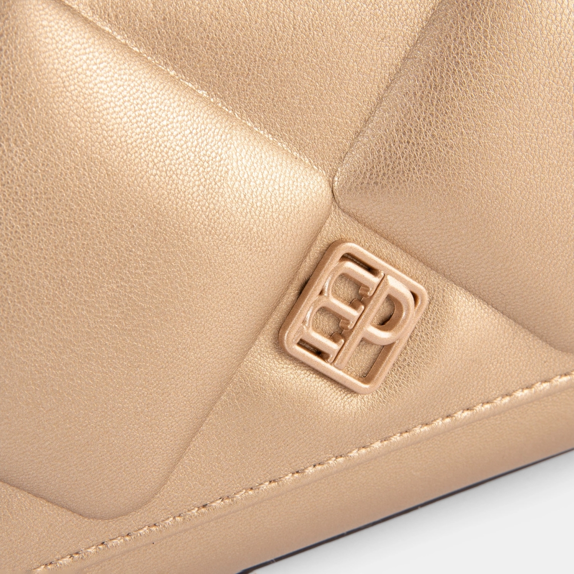 El bolso de hombro de la marca Pepe Moll, modelo TITAN. Elaborado en polipiel acolchado color platino con diseño geométrico. Interior forrado con bolsillo interior para organizar lo imprescindible. Cierre con botón. Cierre superior con solapa imantada y compartimento con cremallera.. Asa trenzada desmontable, perfecta para llevar al hombro o en la mano. Medidas: alto 12cm y ancho 22cm. Este bolso Pepe Moll TITAN es un modelo que combina elegancia y comodidad, con un asa trenzada desmontable que eleva cualquier look.