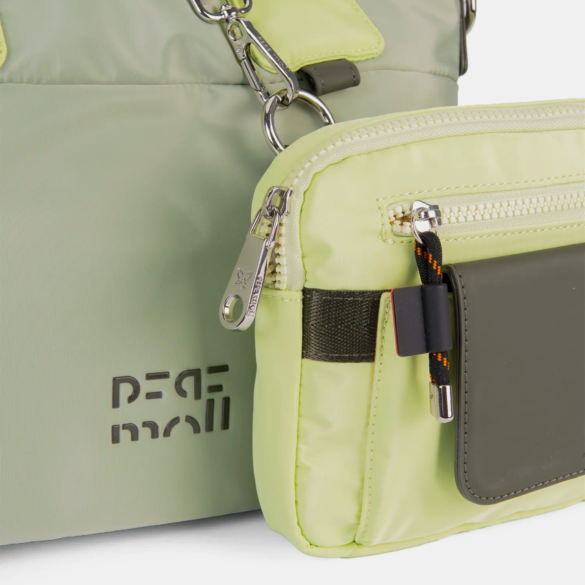 El bolso de mano Pepe Moll , modelo TRINI. Elaborado en naylon color verde, material ligero y resistente, con dierentes compartimentos exteriores, extraíbles. Cierre con cremallera. Medidas: alto 22cm y ancho 30cm. Este bolso Pepe Moll TRINI es el complemento perfecto para quienes buscan funcionalidad sin renunciar al estilo. Su diseño y su textura ligera lo convierten en un imprescindible de temporada.