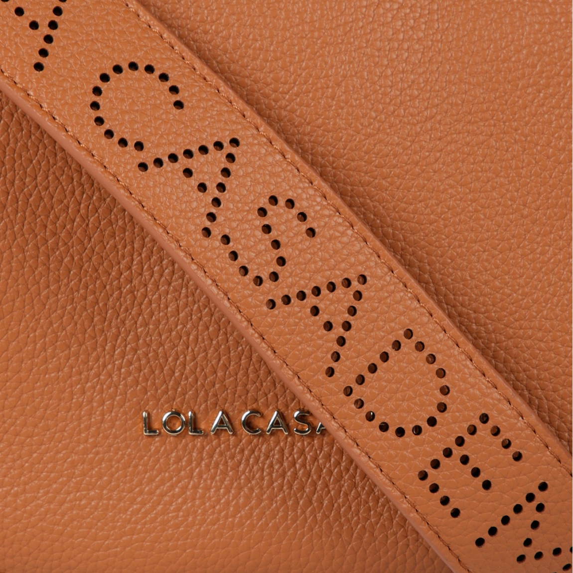 Bolso bandolera mini hobo de la marca Lola Casademunt, modelo ANAHI. Exterior en efecto piel color camel y detalles de tachuelas planas. Contiene compartimento interior y asa bandolera troquelada. Cierre con cremallera.ALTO: 21 cm - LARGO: 38 cm - ANCHO: 10 cm / BANDOLERA: 87 cm