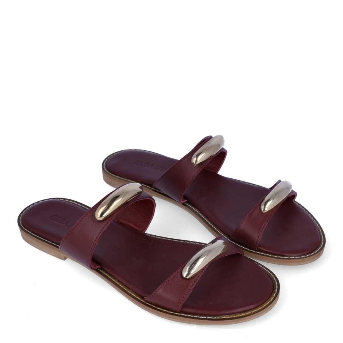 Sandalias de la marca Itse, modelo MISAK. Exterior en piel color granate con tiras en pala con adornos en metal. Interior en piel color granate. Suela plana de goma. Estas sandalias Itse MISAK son ideales para esta temporada, en donde lucirás tus looks más frescos y cómodos.