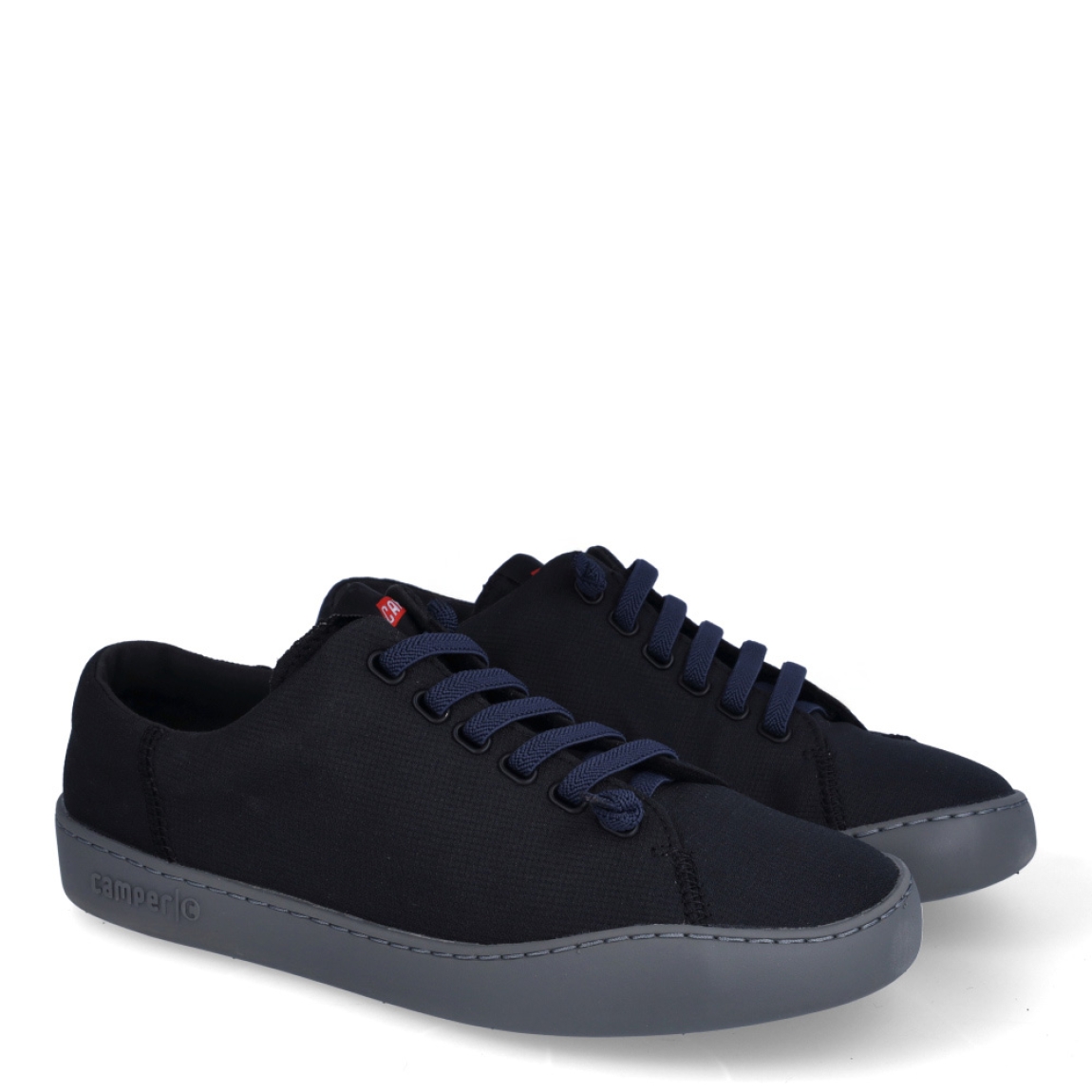 Deportivas clásicas de la marca Camper, modelo K10. Exterior en naylon color negro. Interior con plantilla color rojo. Cierre con cordones negros. Suela de goma plana color negro. Estas deportivas Camper K10 son un complemento ideal para disfrutar de la comodidad al caminar.