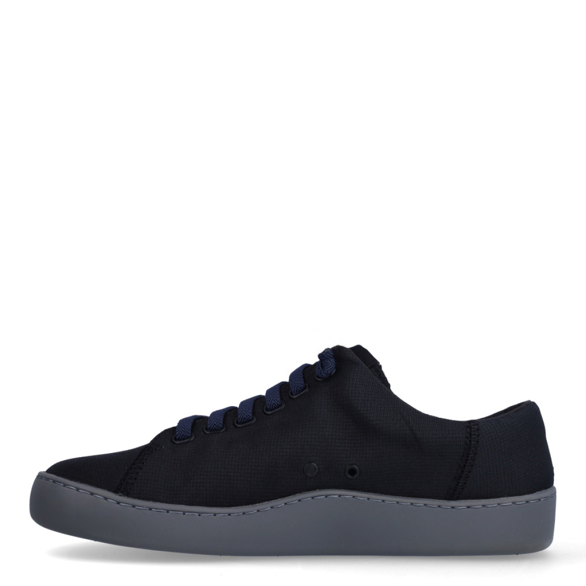 Deportivas clásicas de la marca Camper, modelo K10. Exterior en naylon color negro. Interior con plantilla color rojo. Cierre con cordones negros. Suela de goma plana color negro. Estas deportivas Camper K10 son un complemento ideal para disfrutar de la comodidad al caminar.