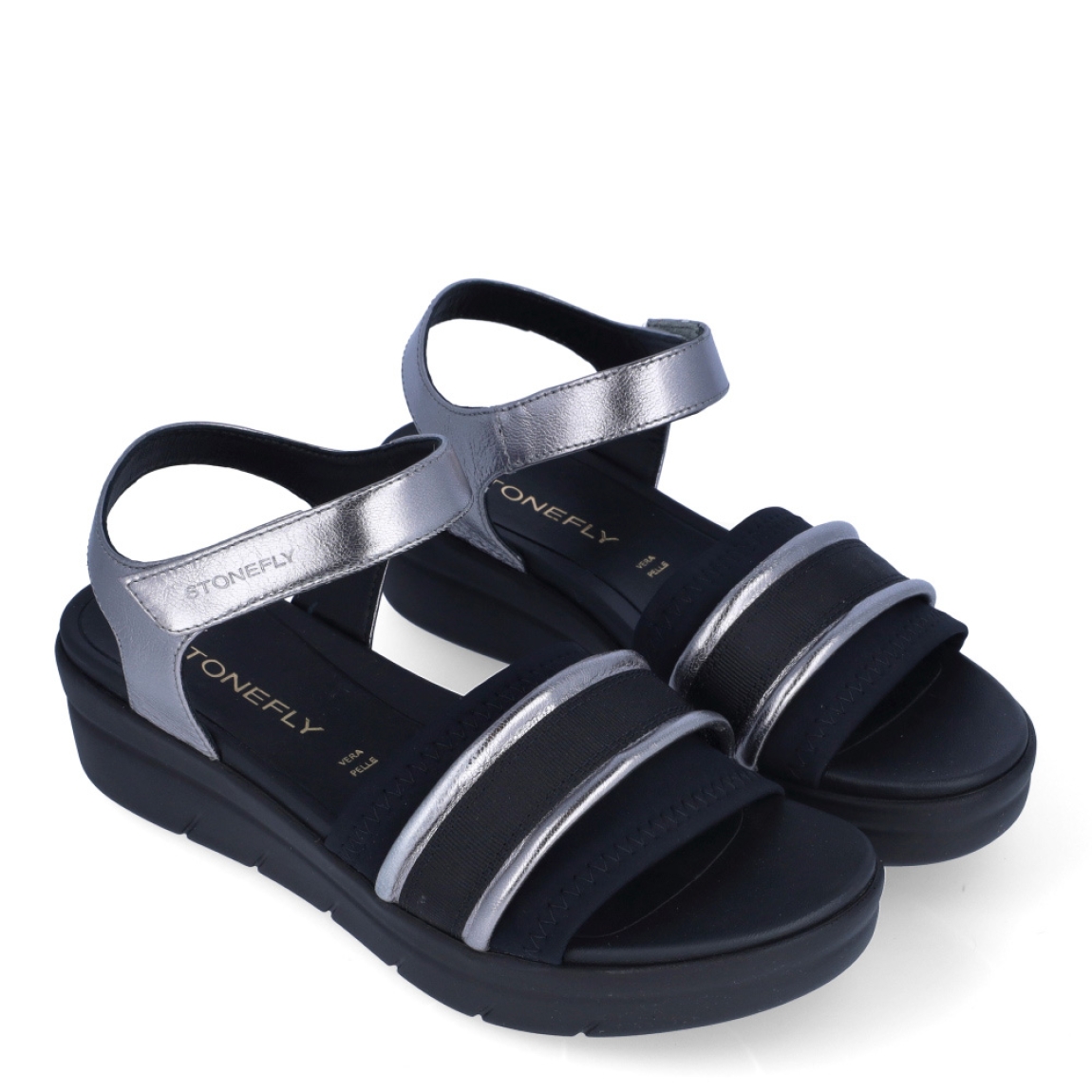 Sandalias clásicas de la marca Stonefly, modelo KIM. Exterior de las sandalias en naylon color negro con detalle en plateado. Interior de las sandalias en piel color negro. Cierre de las sandalias Stonefly con velcro y cuña de 4cm de altura. Estas sandalias Stonefly KIM son el complemento perfecto para tus looks de temporada. No te pueden faltar en el armario.