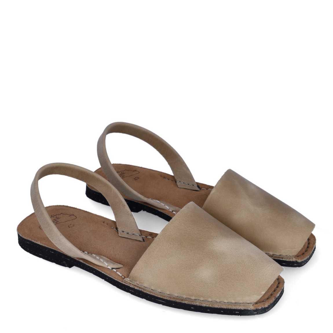 Albarca de la marca Munné, modelo MENORCA. Albarcas clásicas elaboradas en piel color beig con plantilla acolchada y suela plana. Estas albarcas Munné MENORCA son un complemento ideal para combinar tus looks de temporada y disfrutar de una comodidad máxima.