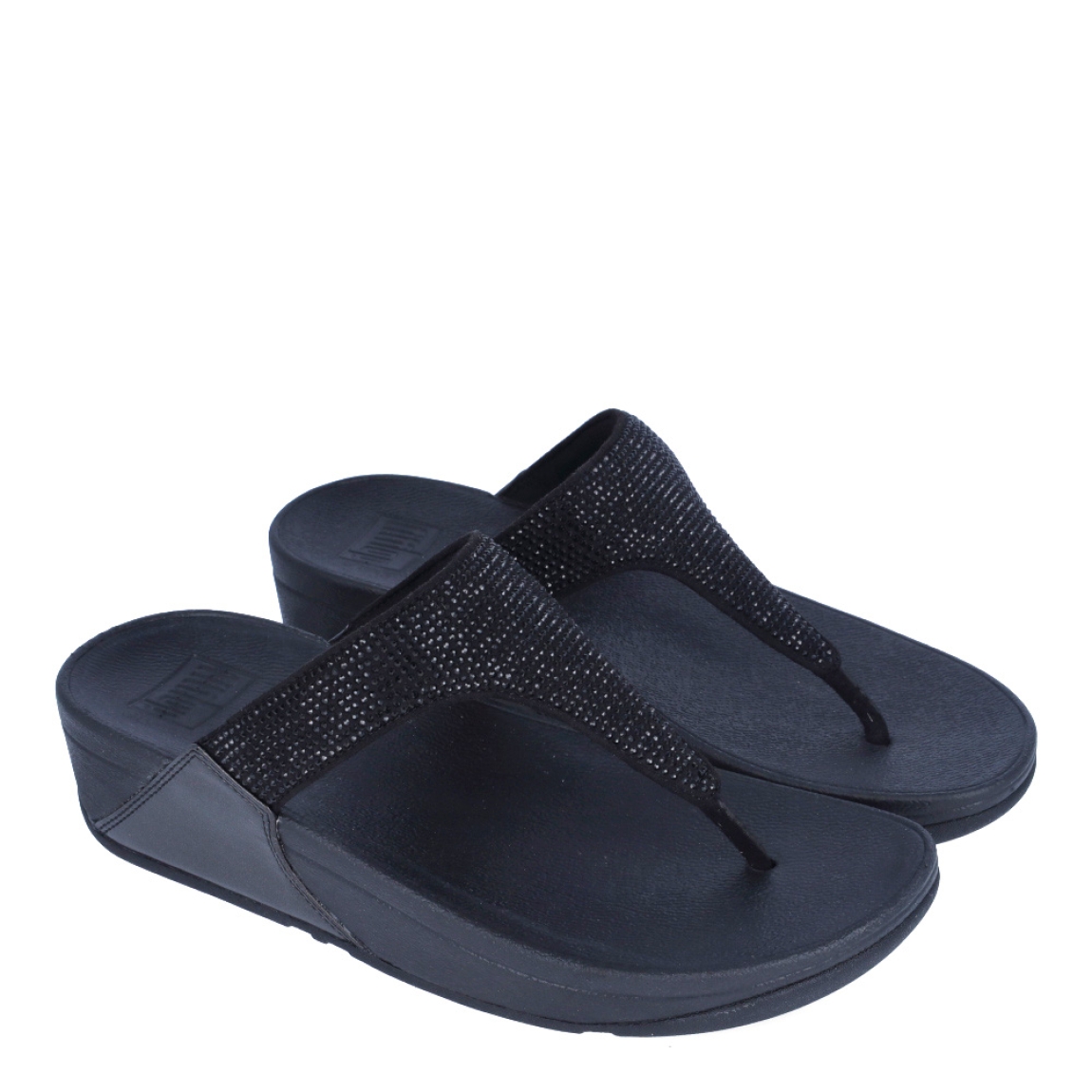 Sandalias de la marca Fitflop, modelo Lulu Crystal. Exterior en ante color negro, decorado con brillantes. Interior en microfibra de color taupe. Suela de caucho antideslizante y planta acolchada. Cuña de 4 cm incluyendo 2,5 cm de plataforma. Con detalle de piel sintética perlada metalizada en los laterales. Fabulosas de día y de noche.