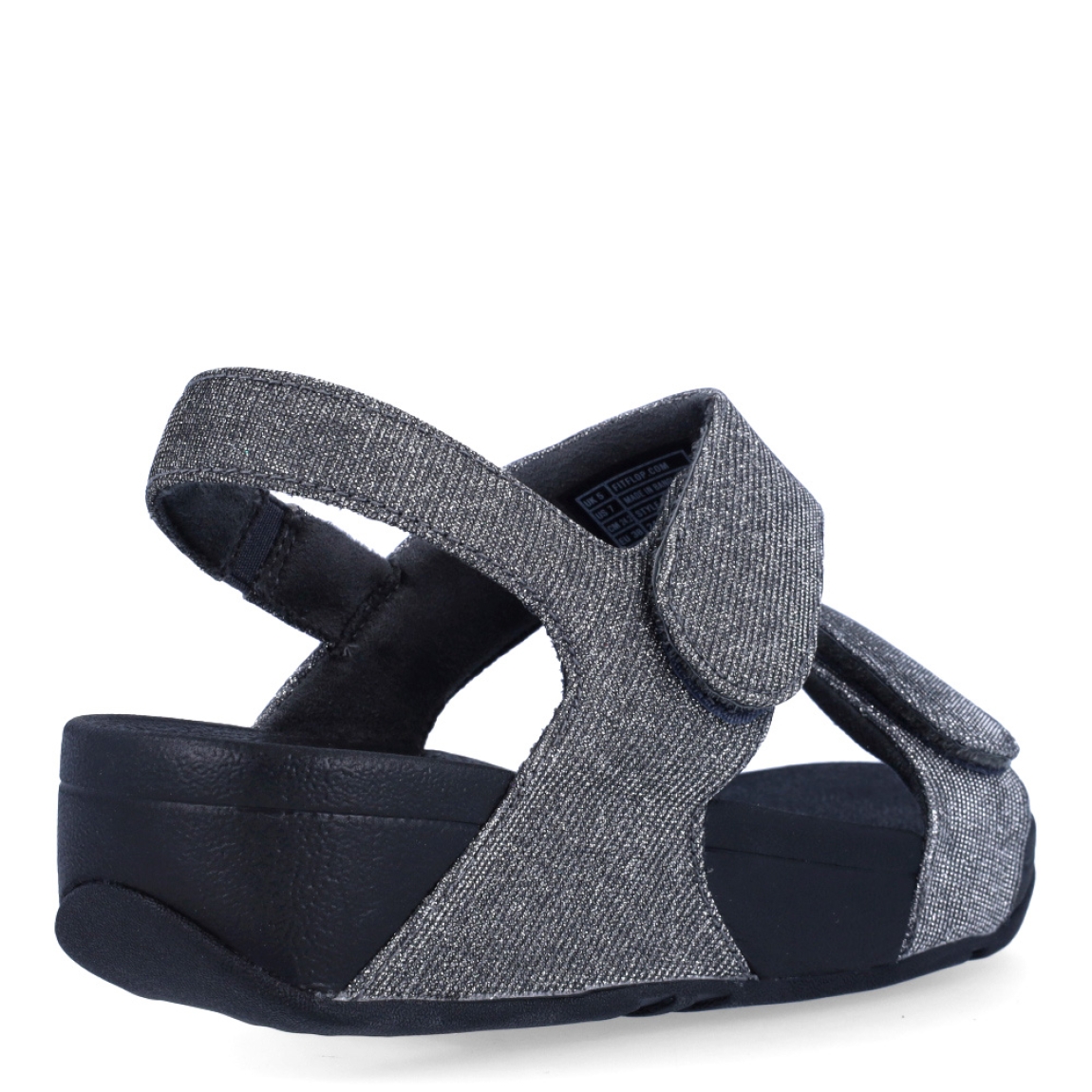 Sandalias de la marca Fitflop, modelo LULU ADJUSTABLE. Exterior en neopreno color gris, decorado con brillantes en pala. Interior en microfibra de color negro. Cierre con doble velcro en la pala. Suela de caucho antideslizante y planta acolchada. Cuña de 4 cm incluyendo 2,5 cm de plataforma. Con detalle de piel sintética perlada metalizada en los laterales. Fabulosas de día y de noche.