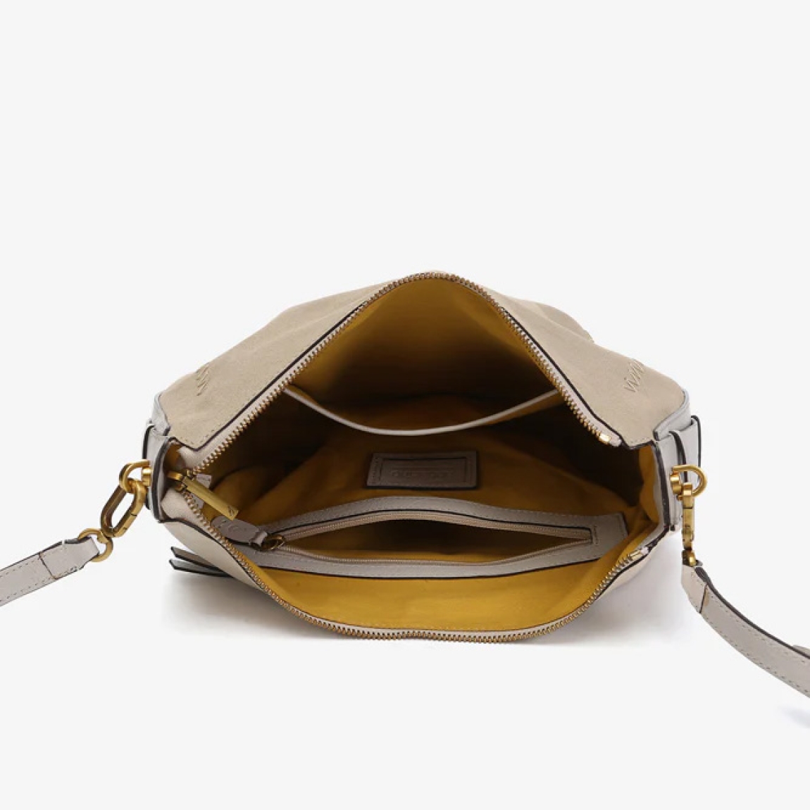 Bolso de hombro de la marca Abbacino, modelo BRUNA. Exterior en piel de ante color beig. En su frontal, destacan grandes pespuntes que combinan con su tono principal. Forro interior. Cierre con cremallera. Este bolso Abbacino BRUNA es un modelo en colores atemporales y muy fáciles de combinar que refleja elegancia y un aire clásico.