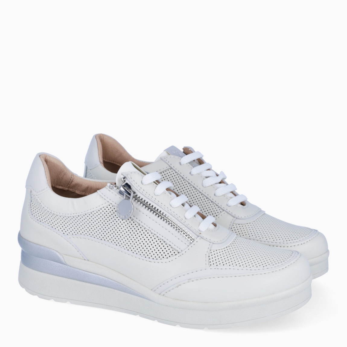Deportivas de la marca Stonefly, modelo CREAM 52. Exterior de las deportivas en piel troquelada color blanco con detalle de cremallera. Interior de las deportivas en piel color beig. Cierre de las deportivas con cordones y cuña de 3cm de altura. Estas deportivas Stonefly CREAM 52 tienen un diseño que ofrece frescura y comodidad en cada paso que des. Perfecto para esta temporada.