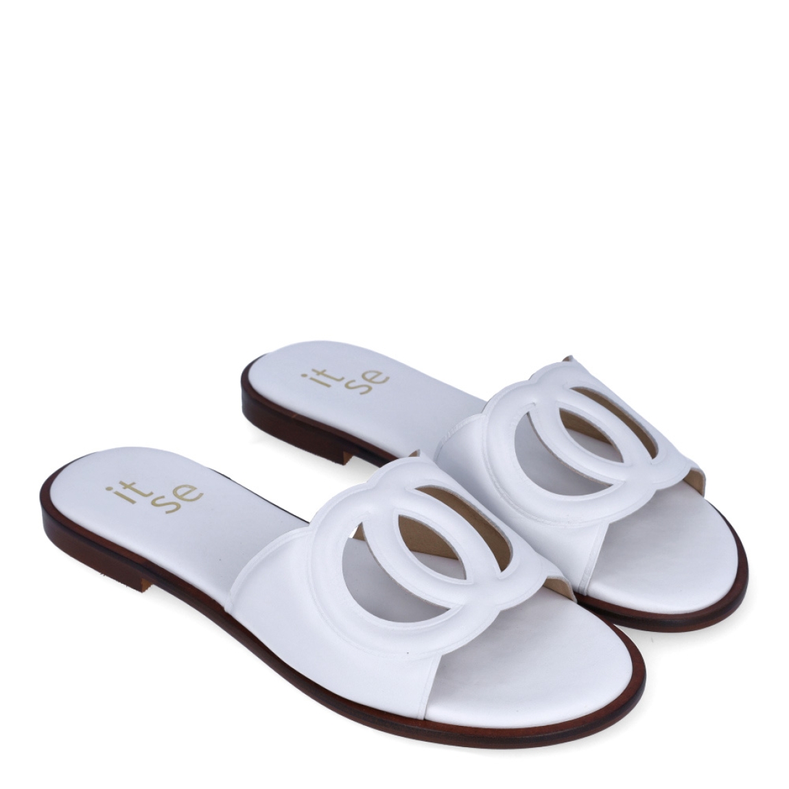 Chanclas de la marca Itse, modelo BRITNE. Exterior en piel color blanco con detalle de círculos cruzados en la pala. Interior en piel color blanco con logo de marca. Chanclas con suela de goma y plana. Estas chanclas Itse BRITNE son unas clásicas, ideales para combinarlas con diferentes looks esta temporada!