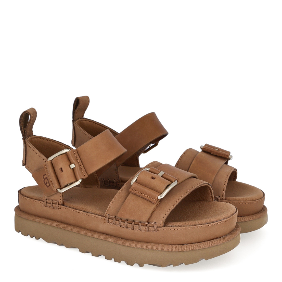 Sandalias de la marca UGG, modelo Goldenstar Villa. Elaboradas en piel color marrón con tiras en la pala. Estas sandalias UGG son ligeras y muy cómodas gracias a la suela de EVA de caña de azúcar y la plantilla contorneada, que las hacen ideales para explorar la ciudad o cualquier otro destino. Las tiras están hechas de una combinación de nobuk suave y piel auténtica y cuentan con una hebilla ajustable en el tobillo para que las adaptes como quieras. Con plataforma de 4cm de altura. Estas UGG Goldenstar Villa, que cuentan con elementos emblemáticos como los ribetes con costuras y detalles de pespunte cuadrado, te permiten disfrutar de la increíble sensación UGG® también durante los meses más cálidos.