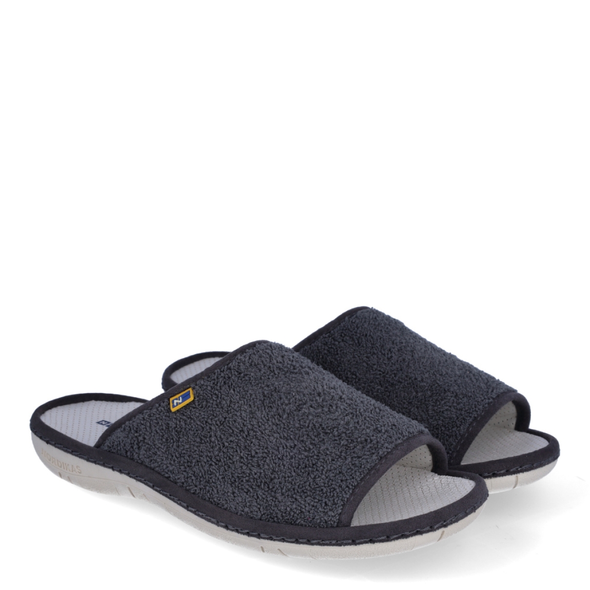 Zapatillas de la marca Nordikas, modelo BOREAL. Exterior de las zapatillas en toalla color gris. Interior de las zapatillas en piel troquelada color blanco. Suela de las zapatillas plana y de goma. Estas zapatillas Nordkias BOREAL te harán disfrutar del comfort de estar en casa, gracias a su tejido y fabricación que brindán comodidad y ligereza.