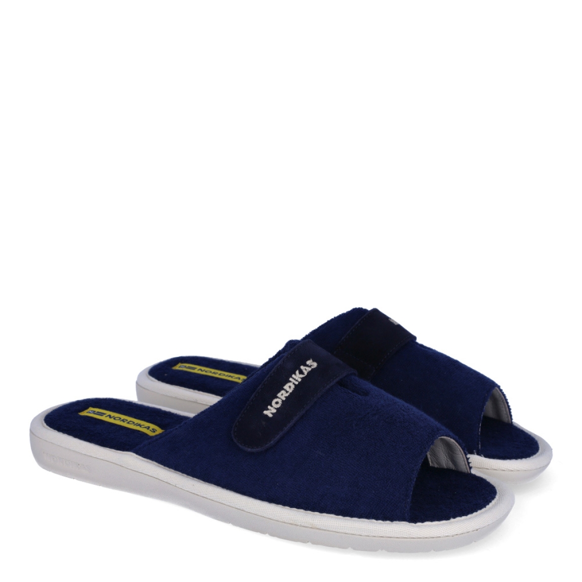 Zapatillas de la marca Nordikas, modelo TOP LINE. Exterior e interior de las zapatillas en toalla color azul. Cierre de las zapatillas con velcro y suela de goma plana. Estas zapatillas Nordikas TOP LINE, te hará disfrutar de la comodidad y ligereza de estar por casa.