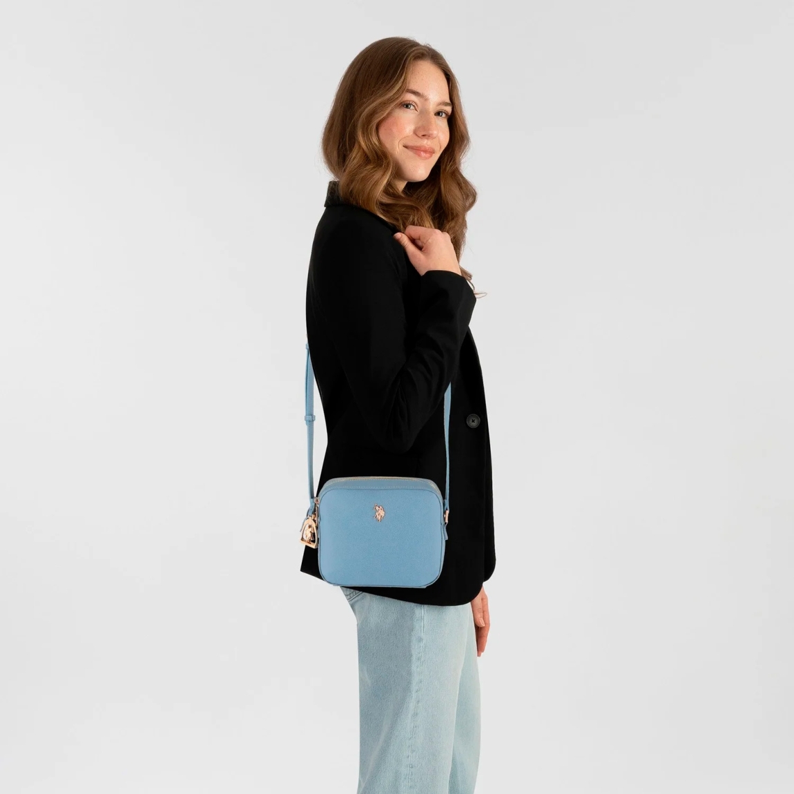 Bolso de la marca US POLO, modelo JONES. Bolso elaborado en piel color azul con logotipo en parte frontal. Cuenta con un ingenioso compartimento con cremallera y un útil bolsillo para el móvil que puede abrirse sin esfuerzo. La cremallera, elegante y práctica a la vez, mantiene sus pertenencias a buen recaudo y siempre fácilmente accesibles. Otra característica destacada es la correa para el hombro desmontable y ajustable. Gracias a su gran longitud, ofrece diversas opciones de transporte que se adaptan a su estilo personal. Medidas: alto 17cm y ancho 20cm. Este bolso US POLO JONES es un clásico, complemento ideal en elegancia y comodidad para diferentes looks!