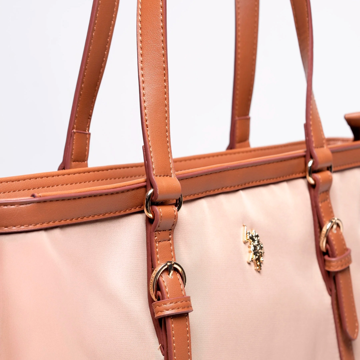 Bolso de la marca US POLO, modelo MASON. Elaborado en naylon color camel con logotipo en parte frontal. Cierre con cremallera y forro interior de tela. Este bolso shooper cuenta con una asa principal con detalle de hebillas, con una longitud media que ofrece sujeción sin concesiones. Medidas: alto 27cm y ancho 33cm. Este bolso US POLO MASON es un clásico para llevar a todos lados!