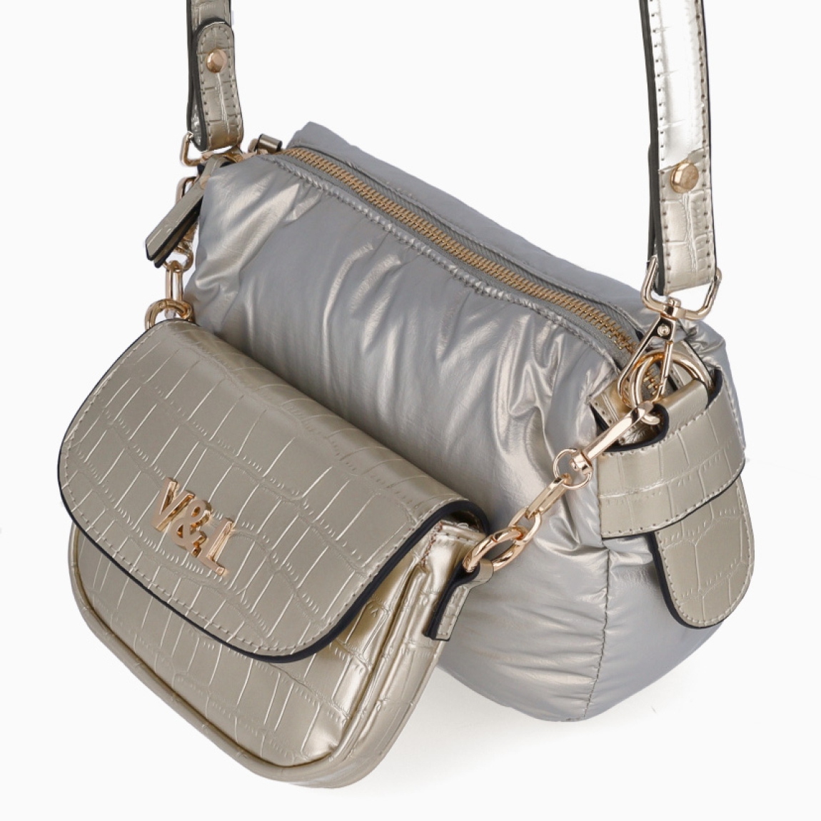 Bolso de la marca Victorio & Lucchino, modelo JULIET. Elaborado en plástico color plata con detalles en dorado y bolsillo desmontable en parte frontal. Interior con compatimentos. Cierre de bolso con cremallera. Bolso con una asa de hombro extraíble para máxima comodidad. Medidas: alto 16cm y ancho 24cm. Este bolso Vitorio & Lucchino JULIET es ideal para esta temporada!