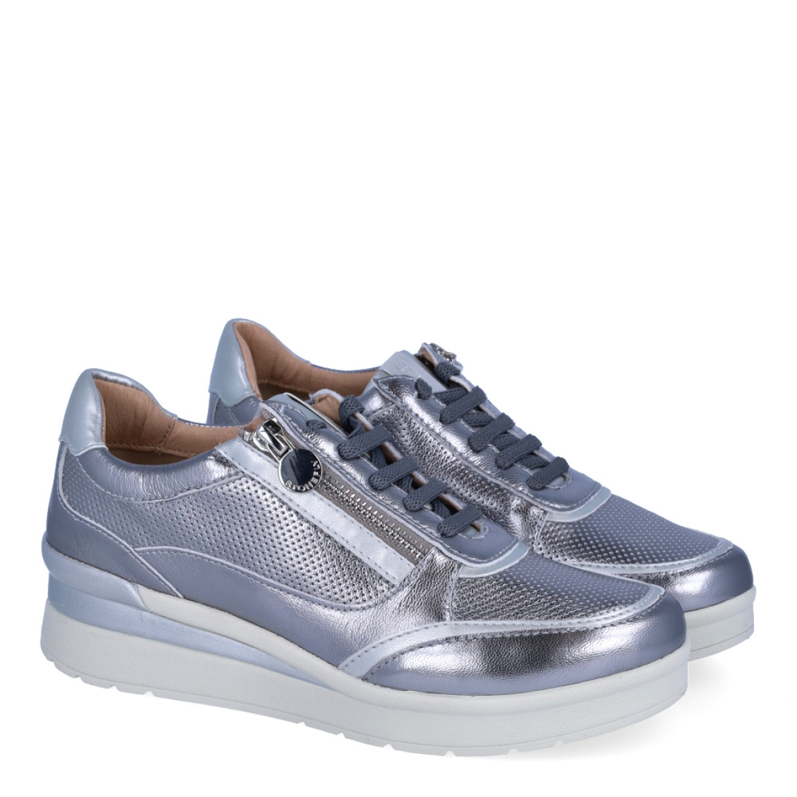 Deportivas de la marca Stonefly, modelo CREAM 52. Exterior de las deportivas en piel troquelada color plata con detalle de cremallera. Interior de las deportivas en piel color beig. Cierre de las deportivas con cordones y cuña de 4cm de altura. Estas deportivas Stonefly CREAM 52 tienen el diseño ideal para disfrutar de frescura y comodidad al caminar. Perfecto para esta temporada.