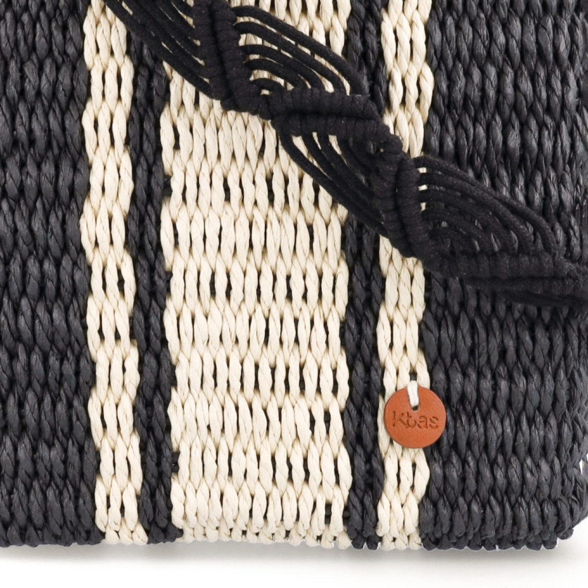 Bolso de la marca Kbas, modelo BLER. Exterior en rafia trenzada color negro con detalles de rayas blancas. Cierre del bolso con cremallera. Interior con amplio espacio para llevar lo que necesites a donde vayas. Cuenta con una asa de mano y una regulable y extraíble para máxima comodidad. Medidas: alto 22cm y ancho 25cm. Este bolso Kbas BLER es un complemento ideal para llevar con tus looks de temporada!