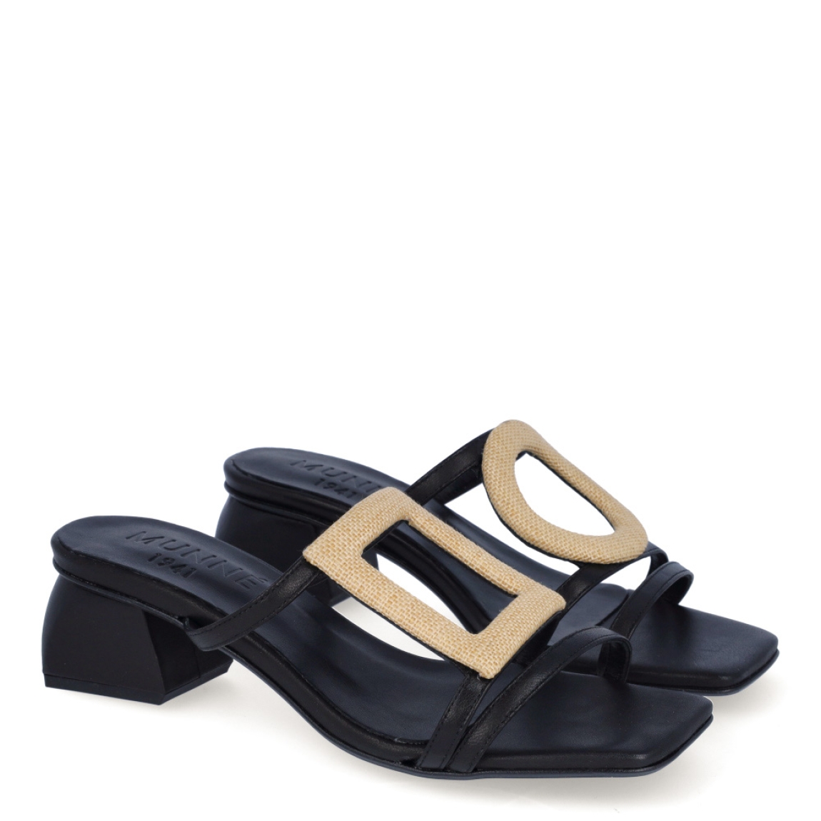 Sandalias de la marca Munné, modelo SOLER. Exterior de las sandalias en piel color negro con tiras en pala y detalle de adorno en forma de cuadrado y círculo. Sandalias con puntera plana. Interior de las sandalias en piel color negro. Sandalias Munné con tacón de 4cm de altura. Estas sandalias Munné SOLER están inspiradas en la comodidad y elegancia sutil. Un complemento esencial para esta temporada.