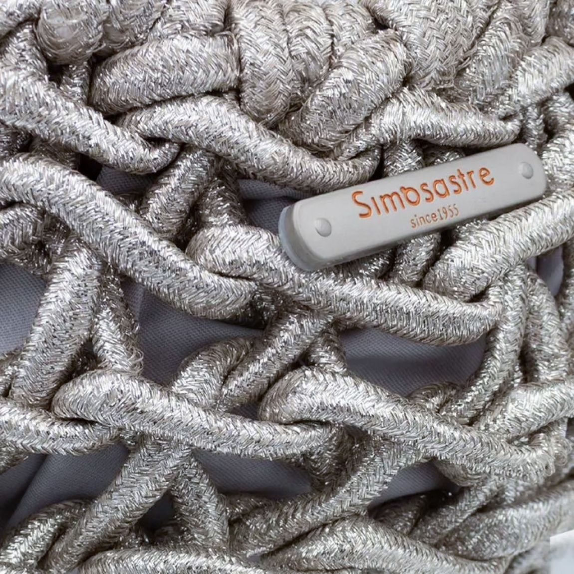Bolso de la marca Simosastre, modelo ELOISE. Bolso fabricado en tejido de tela con forma de cuerdas color plata con efecto escarchado, con cierre cremallera y bolsillos interiores, asa en aros metálicos y cadena fina. Medidas: alto 14cm y ancho 22cm. Este bolso Simosastre ELOISE es ideal para lucirlo esta temporada!