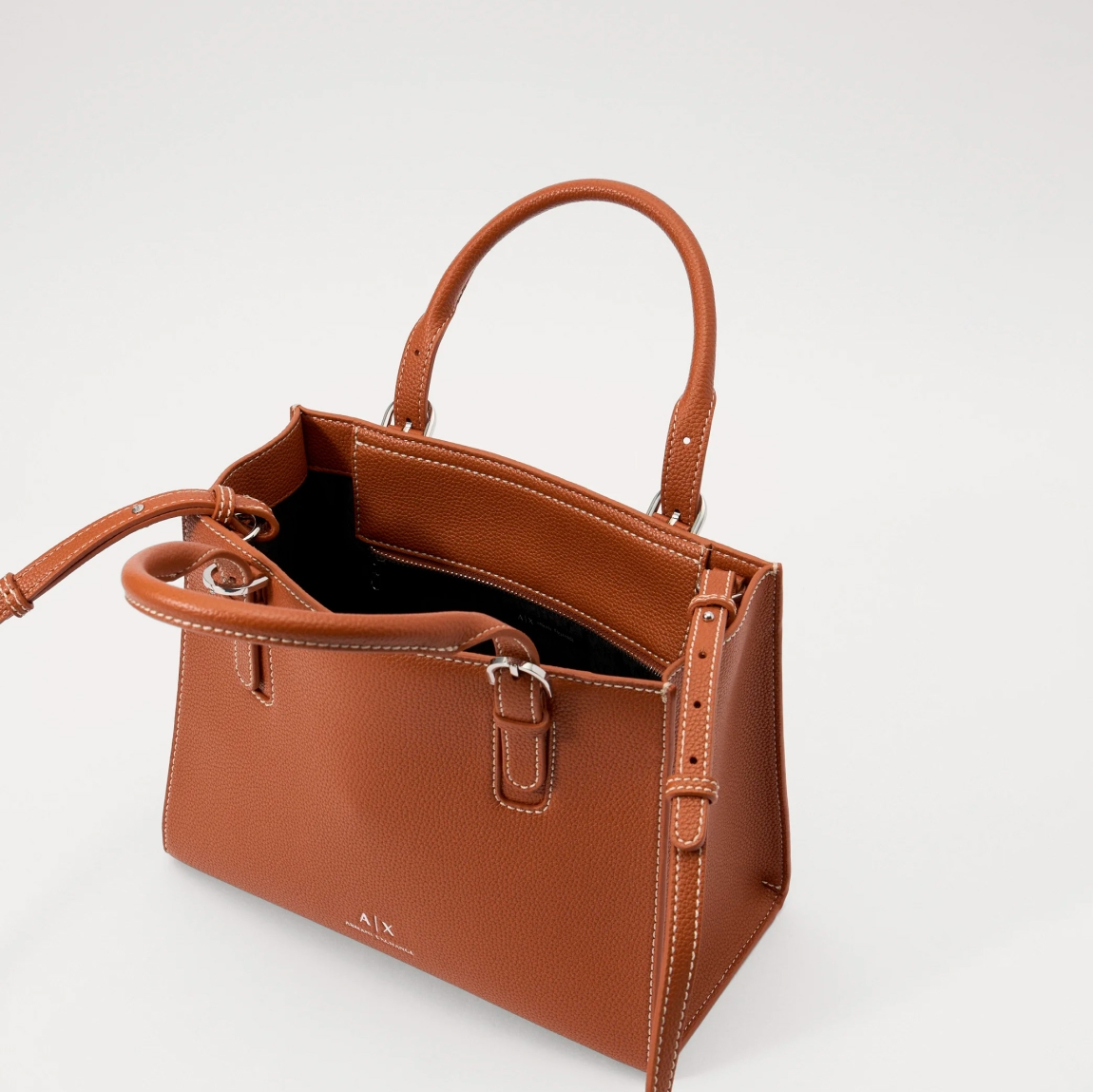 Bolso clásico de la marca Armani Exchange, modelo LOUS. Exterior en piel color marrón, con logo en parte frontal. Cierre con cremallera, y doble asa, fija y regulable para máxima comodidad. Bolso con amplio espacio interno. Medidas: alto 23cm y ancho 29cm. Este bolso Armani Exchange LOUS es un complemento ideal para esta temporada!