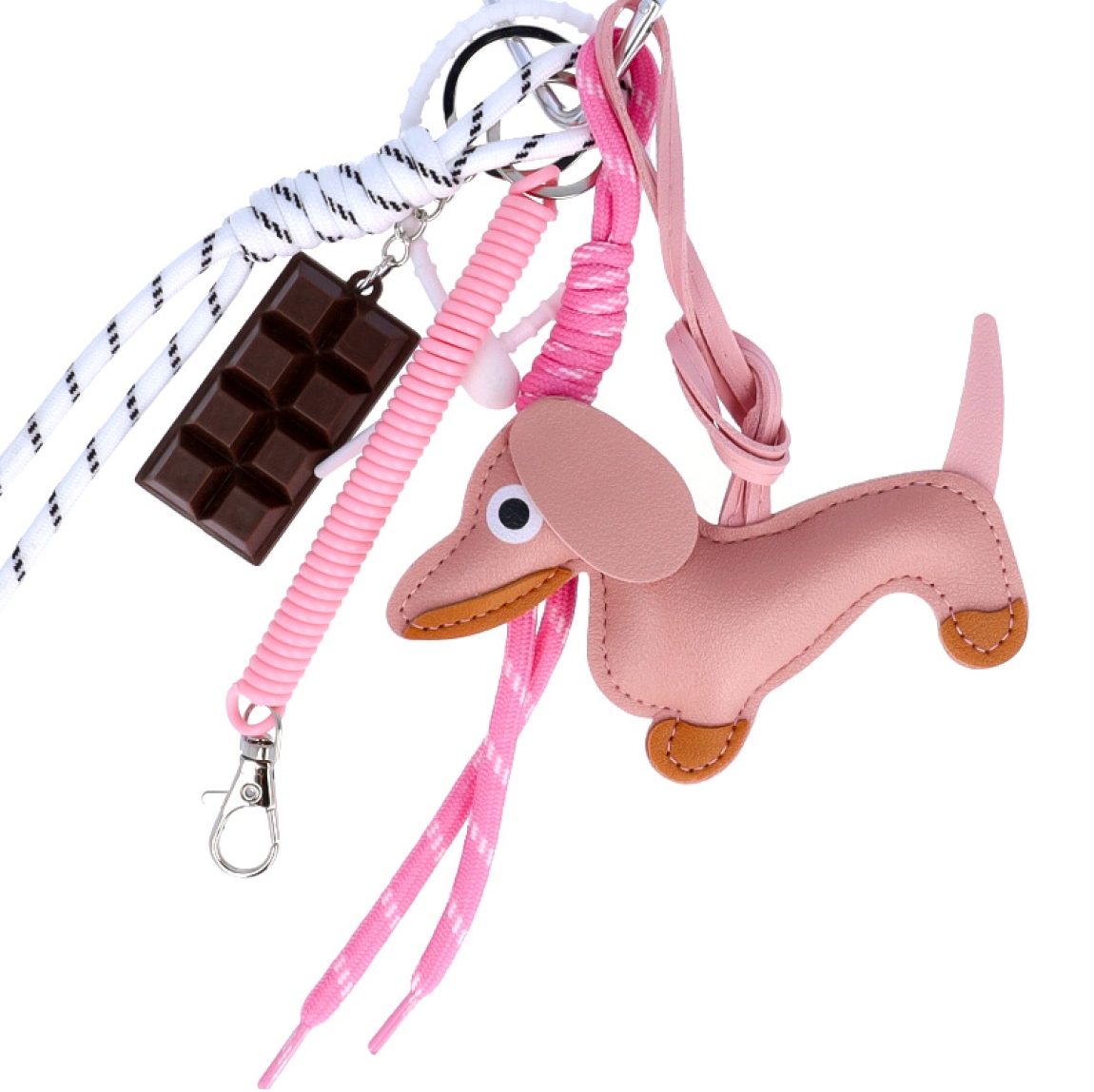 Llavero de la marca MUNNÉ, modelo DOG. Elaborado en piel color rosa con dijes de chocolate y perro salchicha. Complemento perfecto para tu bolso.