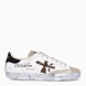 Deportivas de la marca Premiata, modelo STEVEND. Exterior de las deportivas en piel color blanco con logo en amila print y punter escarchada dorada. Interior de las deportivas en piel color blanco. Cierre de las deportivas con cordones a tono y suela plana color plata. Deportivas Premiata Stevend tienen el diseño perfecto para temporada, no puede faltar este modelo clásico en tu armario!