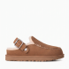 Zuecos tipo mocasín de la marca UGG, modelo GOLDENSTAR EVELINA. Elaborados en ante de primera calidad color cuero. Cuentan con una correa ajustable con hebilla metálica que puedes llevar plegada hacia delante o alrededor del talón. Logotipo de UGG® grabado. Forro interior de piel cálida y plantilla contorneada para un confort absoluto. Suela ligera de goma EVA de caña de azúcar con ligera plataforma y relieve dentado. ¡Estos zuecos UGG GOLDENSTAR EVELINA son un complemento ideal en comodidad y estilo para tus looks de diario!