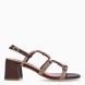 Sandalias de la marca Bibi Lou, modelo QUALI. Elaboradas en material sintético color marrón. Su punta cuadrada aporta modernidad y estructura, mientras que los brillos decorativos añaden un toque elegante y luminoso. Cierre de sandalias Bibi Lou con hebilla en tobillo. Sandalias Bibi Lou de tacón tipo bloque de 6 cm que combinan estilo y comodidad. Sandalias Bibi Lou QUALI, un modelo versátil, perfecto para looks de día, combinaciones urbanas o estilismos informales que requieren un detalle sofisticado.