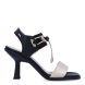 Sandalias de la marca Nerogiardini, modelo DANIA. Exterior de las sandalias en piel color beig. Interior de las sandalias en piel color negro y beig. Cierre de las sandalias Nerogiardini con gomas elásticas color negro. Sandalias con tacon de 6cm de altura. Estas sandalias Nerogiardini DANIA es un complemento clásico, inspirado en la comodidad, ligereza que necesitas en tu día a día.