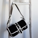 Bandolera de la marca Noco, modelo BAGUE. Bolso elaborado en neopreno color negro y blanco. Esta colección es el equilibrio perfecto entre diseño moderno y funcionalidad. Confeccionada en neopreno negro de alta calidad, este bolso presenta un toque único gracias a sus detalles en piel vegana blanca, que aportan un contraste sofisticado y elegante. Su hebilla metálica en plata, ubicada en el frente y en las correas, es el detalle principal que le da carácter y una vibrante personalidad a este accesorio. Cierre con hebilla. Medidas alto 17cm y ancho 26cm.
